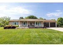 Charming home featuring a welcoming front porch, tidy landscaping, and a two-car garage at 3310 46Th Ne Ave, Hickory, NC 28601
