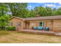 Charming brick home featuring a cozy front porch with outdoor seating and a well-manicured lawn at 366 Faith Rd, Mooresville, NC 28115