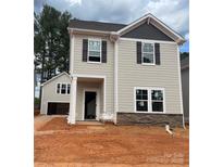 New two-story home featuring gray siding, stone accents, dark shutters, and a welcoming front entrance at 4017 Grommet Ct, Matthews, NC 28105