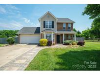 Charming two-story home with brick and siding, landscaped yard, and an attached two-car garage at 4301 Windjammer Sw Ct, Concord, NC 28027