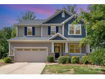 Charming two-story home with a large front yard, covered porch, and attached two-car garage at 5065 Watersail Way, Clover, SC 29710