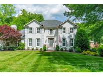 Charming two-story white brick home with lush lawn and manicured landscaping at 5135 Winding Brook Rd, Charlotte, NC 28226