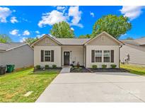 Charming single-story home with a well-manicured lawn, concrete driveway, and welcoming front entrance at 5648 Woodard St, Charlotte, NC 28269