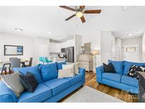 Bright living room features hardwood floors, ceiling fan, and comfortable seating at 5648 Woodard St, Charlotte, NC 28269