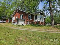 Charming brick home with a classic design, surrounded by lush greenery and a spacious yard at 621 Benton St, Monroe, NC 28110