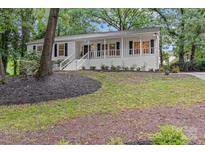 Charming home featuring a welcoming front porch, white facade and landscaped front yard at 6719 Woodshed Cir, Charlotte, NC 28270