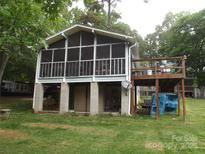 Exterior view showing the screened-in porch and the wooden deck, enhancing outdoor living at 6813 Navajo Trl, Sherrills Ford, NC 28673