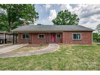 Charming brick home with a pink front door and well-maintained lawn at 85 Sw Myrtle Sw Ave, Concord, NC 28025