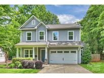 Charming two-story home features a blue front door, grey siding, and a well-maintained lawn at 1209 Leigh Ave, Charlotte, NC 28205