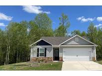 Charming single-Gathering home with stone accents, attached two-car garage, and a well-manicured lawn at 1538 Doran Ter, Richburg, SC 29729