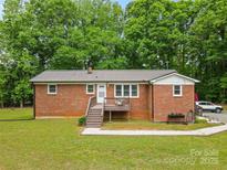 Charming brick home featuring a cozy front porch and a well-maintained yard, perfect for relaxation at 1792 Hoffman Rd, Gastonia, NC 28054