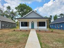 Charming new construction home featuring a covered front porch, teal front door, and minimalist landscaping at 213 Benfield Rd, Kings Mountain, NC 28086