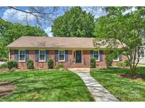 Charming brick home with blue shutters, lush lawn, and inviting walkway leading to the front door at 3901 Kitley Pl, Charlotte, NC 28210