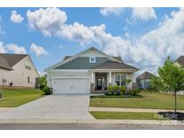 Charming one-story home with well-manicured lawn, attached garage and inviting front porch at 4040 Deep River Way, Waxhaw, NC 28173
