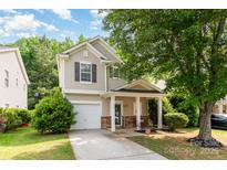Charming two-story home features a welcoming front porch, attached garage, and well-maintained landscaping at 516 Tribune Dr, Charlotte, NC 28214