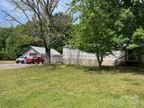 Single-story home with an expansive front yard, a detached garage, and multiple trees providing shade at 6504 Denver Heights Cir, Denver, NC 28037