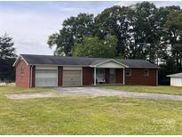 Charming single-story brick home featuring a two-car garage and a well-maintained front yard at 675 E Ritchie Rd, Salisbury, NC 28146