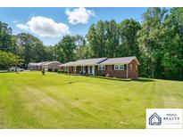 Charming single-story brick home features a manicured lawn and a welcoming covered front porch at 707 Hester Dr, Dallas, NC 28034
