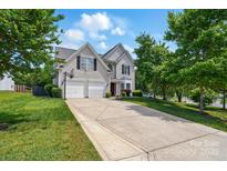 Charming two-story home with a two-car garage, well-manicured lawn, and an extended concrete driveway at 8833 Cavonnier Ln, Charlotte, NC 28216