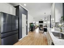 Modern kitchen featuring stainless steel appliances and wood flooring, seamlessly flowing into an open living space at 8833 Cavonnier Ln, Charlotte, NC 28216