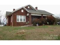 Charming brick home with a covered porch and a spacious front yard at 1040 Nc 90 W Hwy, Taylorsville, NC 20681