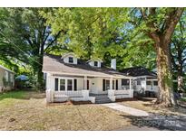 Charming one-story home with dormer windows and a welcoming front porch surrounded by mature trees and ample space at 115 W 5Th Ave, Gastonia, NC 28052
