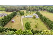 Expansive aerial view of a home, showcasing its large lawn, outbuildings, surrounding trees, and a long driveway at 1720 Lowe Dr, Catawba, NC 28609