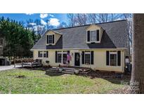 Charming two-story home with a welcoming front porch and a cozy deck, surrounded by lush greenery at 7648 Forest Oak Dr, Denver, NC 28037