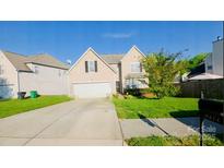 Charming two-story home with a well-manicured lawn and an attached two-car garage at 8414 Oak Ne Dr, Charlotte, NC 28269