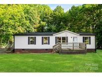 Charming single-story home featuring a spacious front lawn and inviting wooden deck at 1055 Cedar Hill Dr, Rockwell, NC 28138