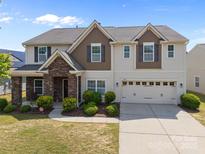 Charming two-story home featuring stone accents, neutral siding, and an attached two-car garage at 13315 Hunting Birds Ln, Charlotte, NC 28278