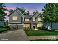 Beautiful two-story home featuring a well-lit exterior, manicured lawn, and inviting front porch at 135 Canoe Pole Ln, Mooresville, NC 28117