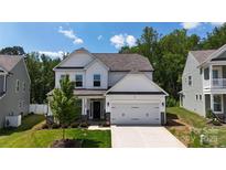 Charming two-story home featuring a well-manicured lawn and a two-car garage on a sunny day at 154 Cotton Field Dr, Statesville, NC 28677