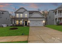 Charming two-story home features a well-manicured lawn, two-car garage, and inviting front porch at 154 Cotton Field Dr, Statesville, NC 28677