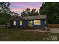 Charming single-story home with a well-manicured lawn and inviting yellow door at 1724 Virginia St, Monroe, NC 28110
