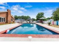 Backyard features a sparkling in-ground pool with a gazebo and patio furniture for relaxing and entertaining at 312 Rumple St, Troutman, NC 28166