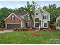 Beautiful two-story brick home with manicured lawn, mature tree, and attached two car garage at 3721 Providence Plantation Ln, Charlotte, NC 28270