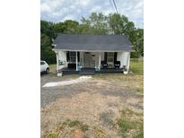 Charming single-story home featuring a cozy front porch, vinyl siding, and gravel driveway at 642 Boger St, Mooresville, NC 28115