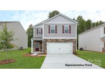 Charming two-story home with stone accents, a well-manicured lawn, and an attached two-car garage at 917 Two Brothers Ln, York, SC 29745