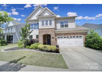 Charming two-story home featuring stone accents, a two-car garage, and a beautifully landscaped front yard at 1001 Emory Ln, Fort Mill, SC 29708