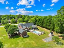Expansive aerial view of a brick home with a pool, shed, and lush green lawn surrounded by mature trees at 1305 Glenview Ln, Rock Hill, SC 29730
