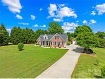 Charming brick home with well-manicured lawn, mature trees, and inviting curb appeal on a beautiful sunny day at 1305 Glenview Ln, Rock Hill, SC 29730