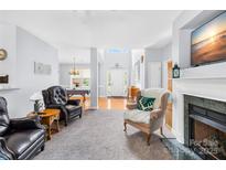Inviting living room with comfortable armchairs, a fireplace, and a view to the front entry and game room at 1305 Glenview Ln, Rock Hill, SC 29730