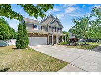 Charming two-story home featuring a stone and siding facade, attached garage, and well-manicured front lawn at 142 Wellshire St, Mooresville, NC 28115