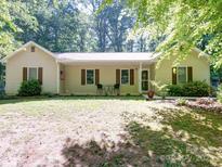 Charming ranch style home with neutral siding, shutters, and a front porch area with seating at 145 Woodview Dr, Statesville, NC 28625