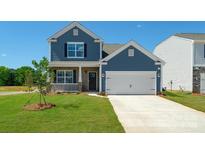 Two-story blue home featuring a manicured lawn and a two-car garage at 207 Giant Oak Ave, Statesville, NC 28677