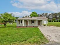 Charming single-story home with a covered front porch, attached carport, and well-maintained lawn at 210 Stonefield Ln, Salisbury, NC 28146