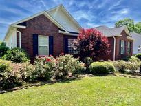 Charming brick home featuring a well-manicured lawn and colorful landscaping with flowering bushes at 2547 Bill Thompson Rd, Lancaster, SC 29720