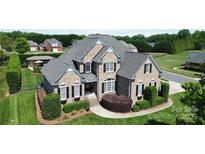 Beautiful two-story brick home featuring a well-manicured lawn and mature landscaping with a classic design and inviting curb appeal at 3000 J R Ct, Stanley, NC 28164