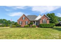 Charming brick home with manicured lawn, detailed landscaping, and traditional architectural details at 3124 Fairmead Dr, Concord, NC 28025